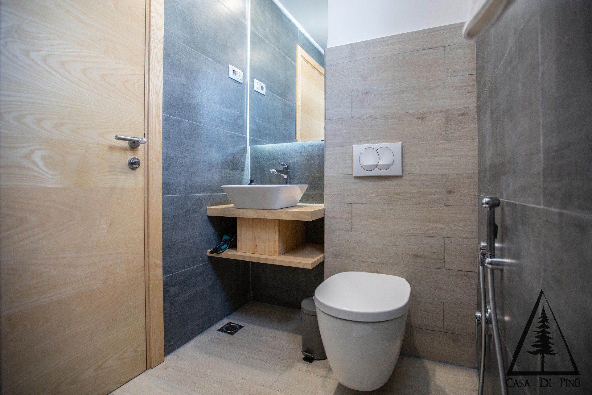 A bathroom with a toilet, sink and mirror.
