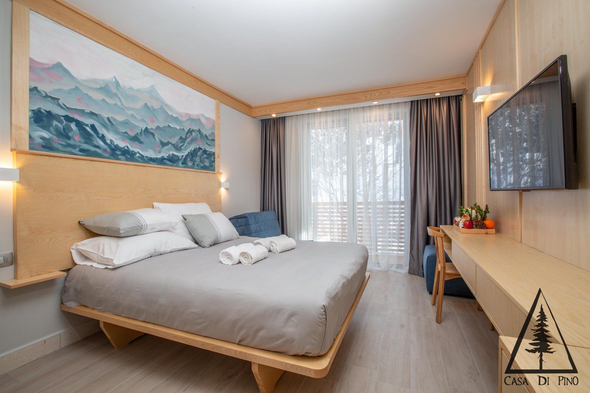 A hotel room with a king size bed and a flat screen tv.