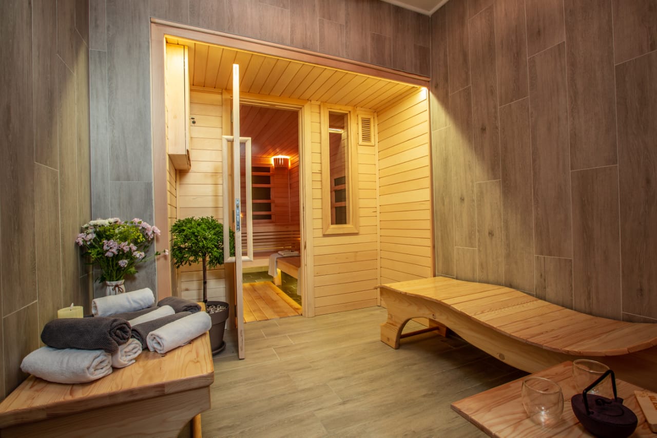 A wooden sauna with a wooden bench and towels.