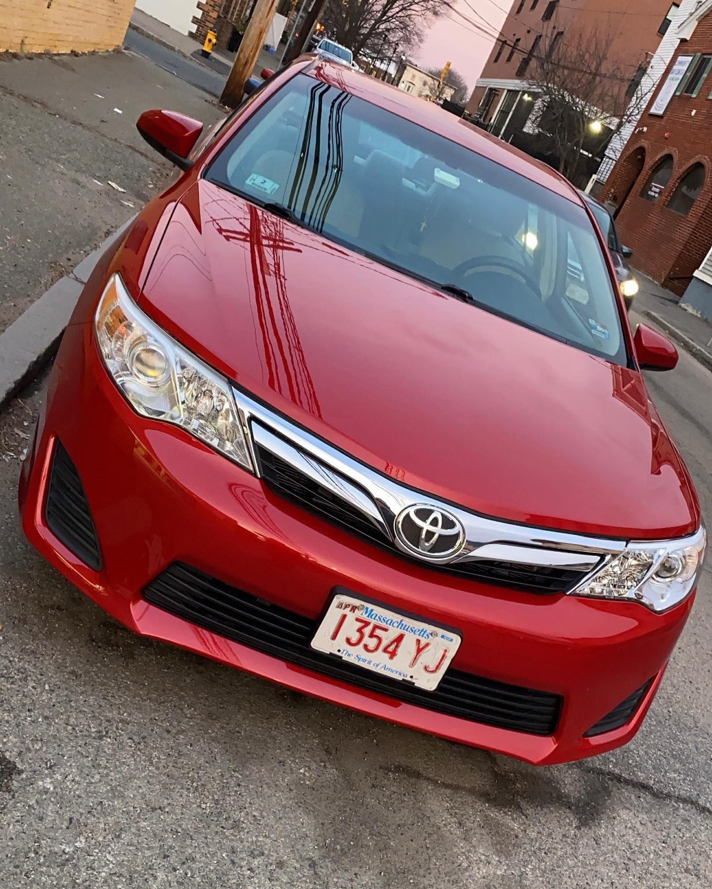 Red Toyota Camry parked on a street; Massachusetts license plate.