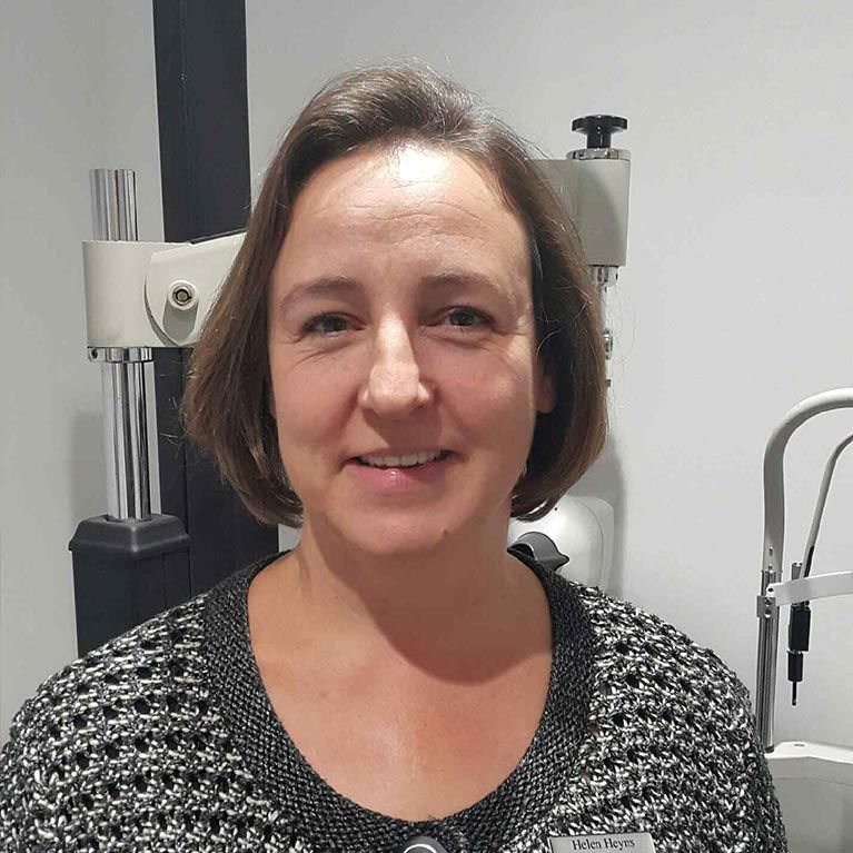 Portrait of a smiling woman in a clinic, with medical equipment in the background