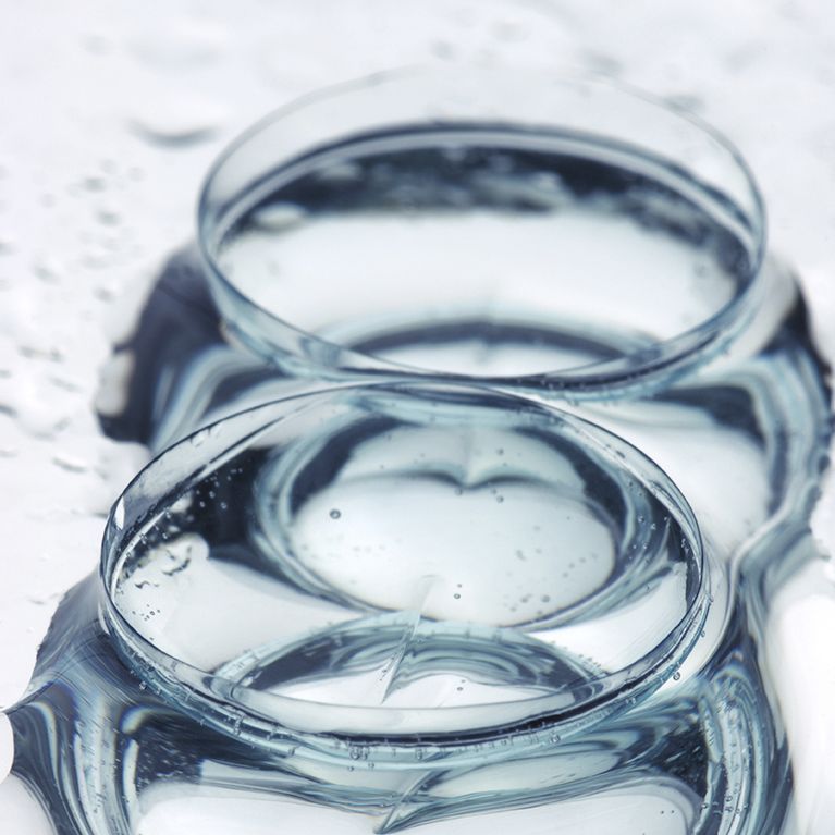 Two clear glass bowls filled with water on a light surface