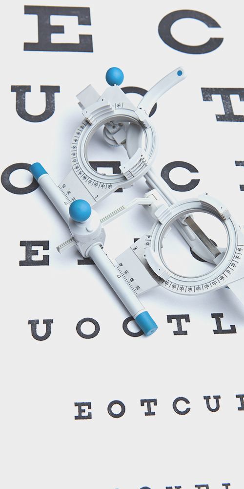 White eyeglasses with blue accents on an eye chart background