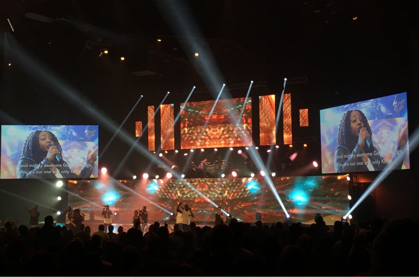 a group of people on a stage with bright lights Redemption project