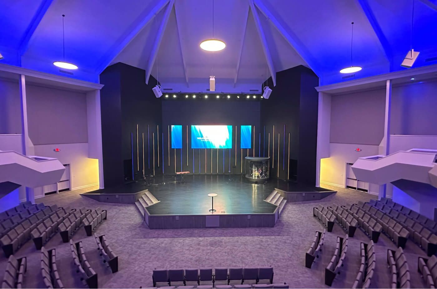 a stage with chairs in a room with lights Shirley Hills project