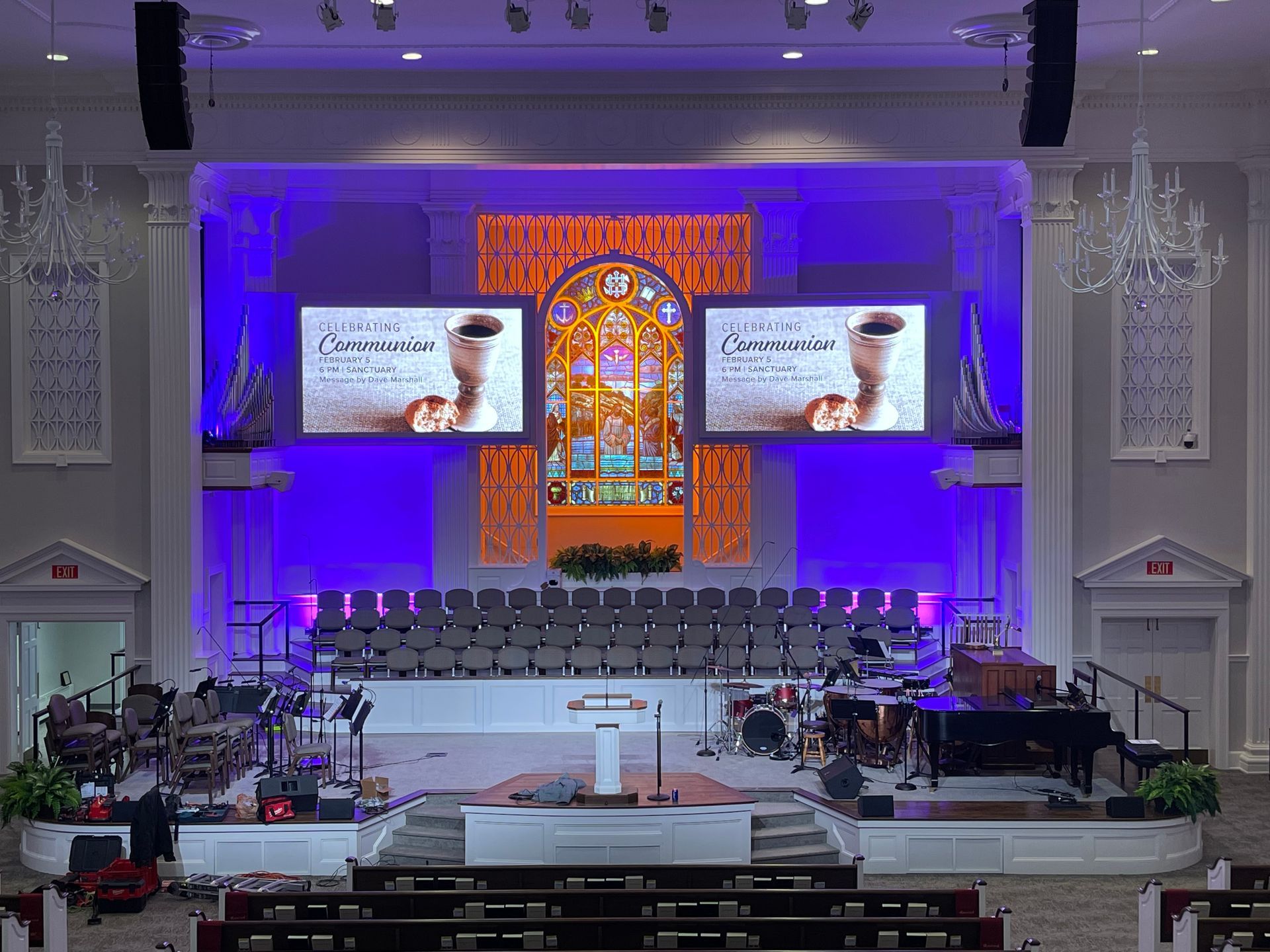 The inside of a church with purple lights on the walls.