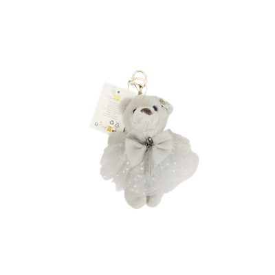 Een lichtgrijze pluche teddybeer sleutelhanger met een glinsterend tule tutu en een strik, met een aangehecht productlabel.