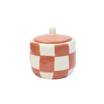 Een kleine, ronde keramische suikerpot met bijpassend deksel, voorzien van een terracotta en wit geblokt patroon.