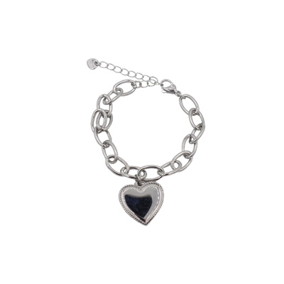 Een zilverkleurige schakelarmband met een grote, hartvormige hanger met een gepolijst, reflecterend middenstuk.