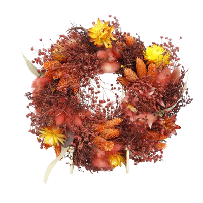 Een krans van gedroogde bloemen met warmgele bloemen, oranje pluimen en roodachtig blad op een witte achtergrond.