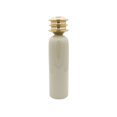 Een beige, cilindrische keramische vaas met een gestapelde, metallic goudkleurige halsdop tegen een witte achtergrond.
