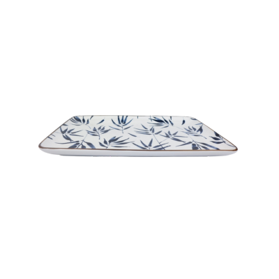Een rechthoekige witte serveerschaal met een blauw bamboebladpatroon, tentoongesteld op een klein metalen onderstel.