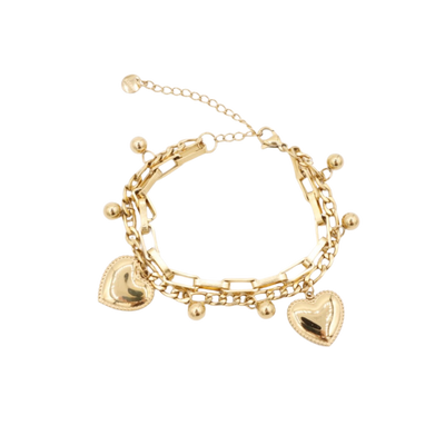 Een goudkleurige armband, versierd met twee bolvormige hartvormige bedeltjes en kleine decoratieve kraaltjes.