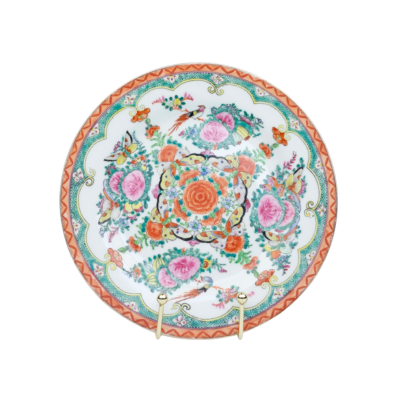 Een decoratief, rond porseleinen bord met een kleurrijk bloemen- en vogelmotief op een witte achtergrond.