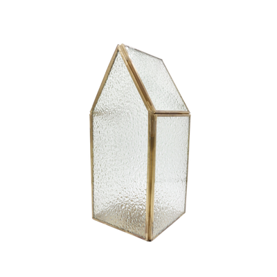 Een klein, huisvormig glazen terrarium met een goudkleurig metalen frame en getextureerde, doorschijnende glazen panelen.