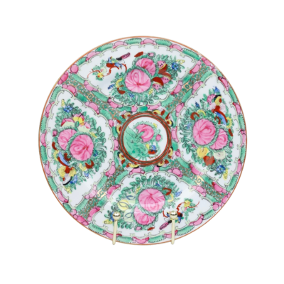 Een decoratief porseleinen bord met levendige roze bloemen, groen blad en vogels in een symmetrisch, paneelachtig ontwerp.
