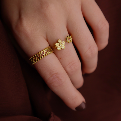 Gouden ring met open band, voorzien van een herhalend zigzag-uitgesneden patroon en parelranden.