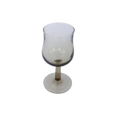Een wijnglas op voet met een licht afgeronde kelk, waarin het glas een subtiele grijze tint heeft.