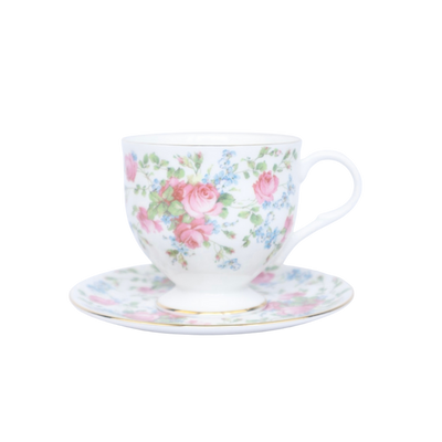 Een wit theekopje met schoteltje, versierd met een patroon van rozen en kleine blauwe bloemen op een effen witte achtergrond.