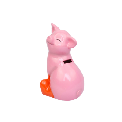 Een roze keramische spaarpot met oranje pootjes, zittend en glimlachend met gesloten ogen.