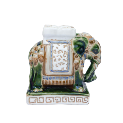 Een groen-wit keramisch olifantenbeeldje op een rechthoekige sokkel met een decoratief Grieks sleutelmotief.