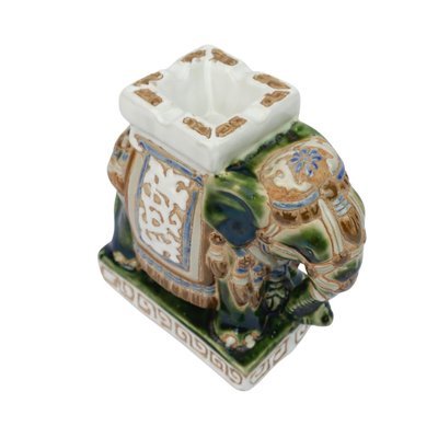 Een groen-wit keramisch olifantenbeeldje op een rechthoekige sokkel met een decoratief Grieks sleutelmotief.