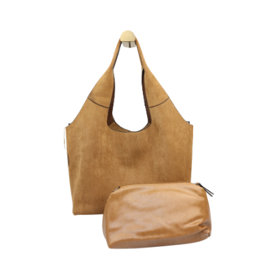 Een minimalistische, beige suède hobo-schoudertas die tegen een witte achtergrond hangt.
