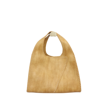 Een beige handtas van imitatie suède met een afgerond handvat en een enkele diagonale naad, hangend op een witte achtergrond.