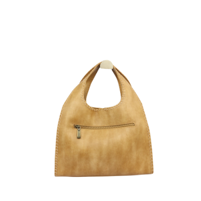 Een beige handtas van imitatie suède met een afgerond handvat en een enkele diagonale naad, hangend op een witte achtergrond.