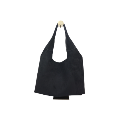 Een zwarte suède schoudertas in hobo-stijl hangt aan een muurhaak tegen een effen witte achtergrond.