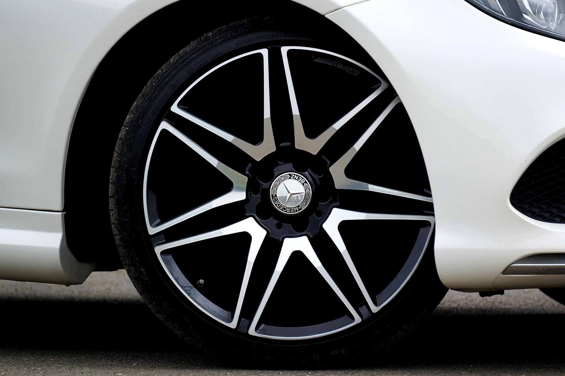 Close-up of a white car’s black and silver alloy wheel