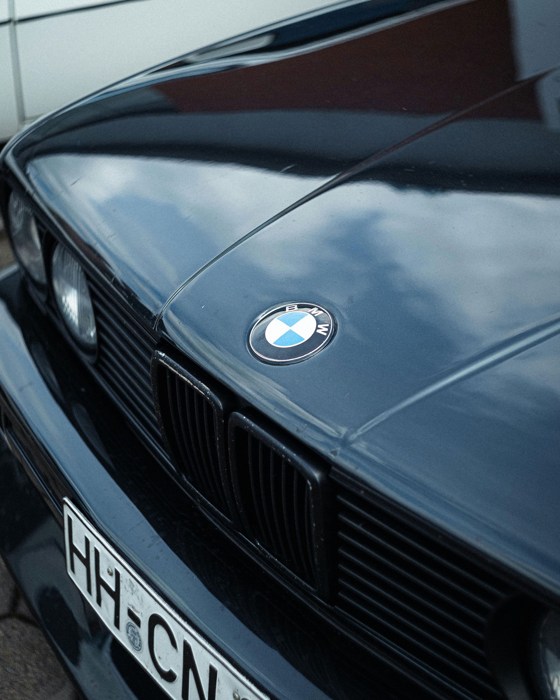 Close-up of a black BMW hood and grille with the BMW emblem visible.