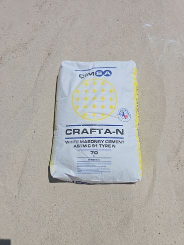 Bag of CIMA Craft-N white masonry cement on a light-colored surface.