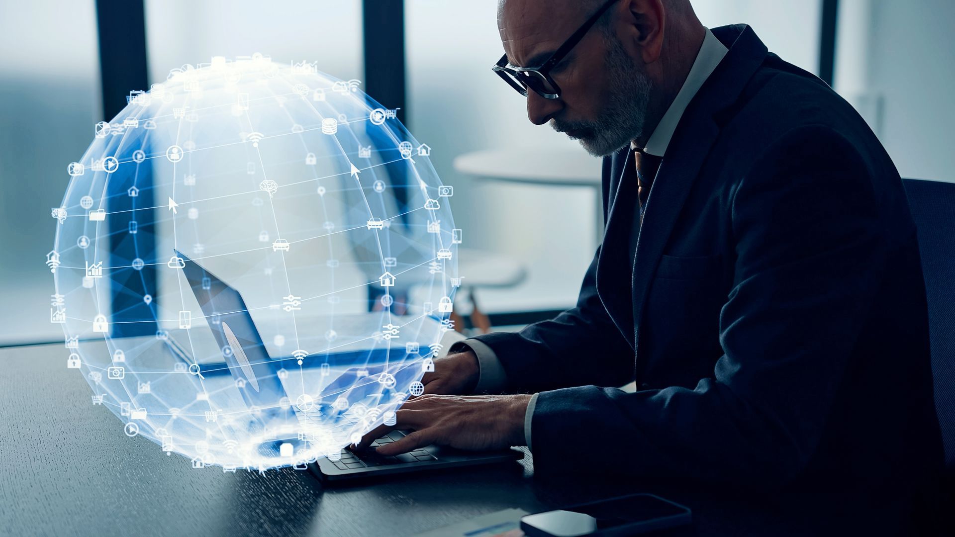Businessman working on a laptop with a glowing digital globe overlay in an office