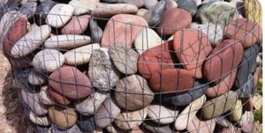 A pile of rocks sitting on top of a wire fence.