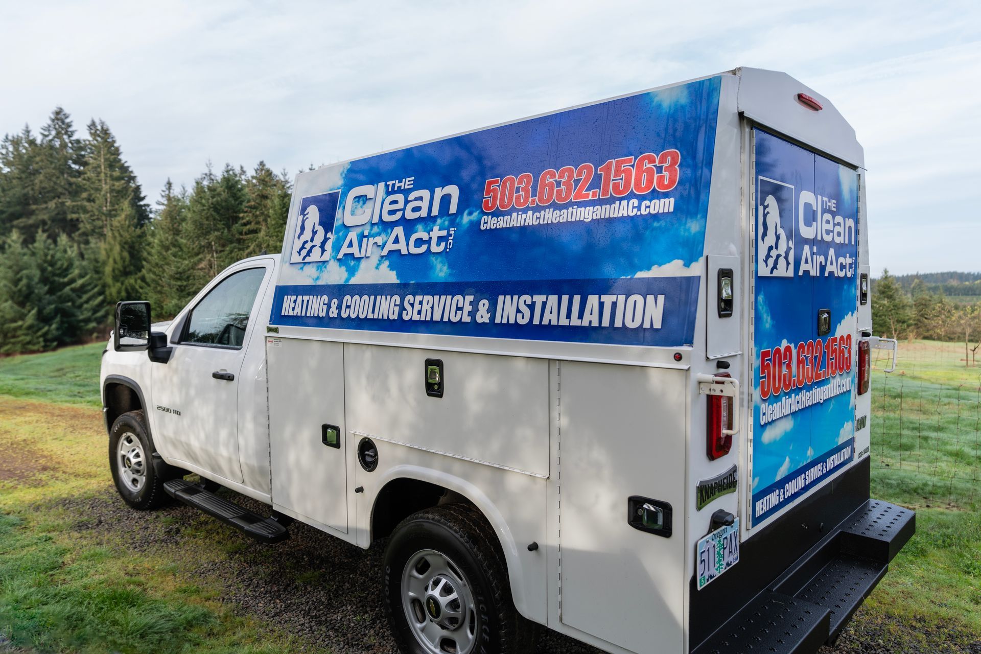 The Clean Air Act Work Truck is parked in a grassy field.