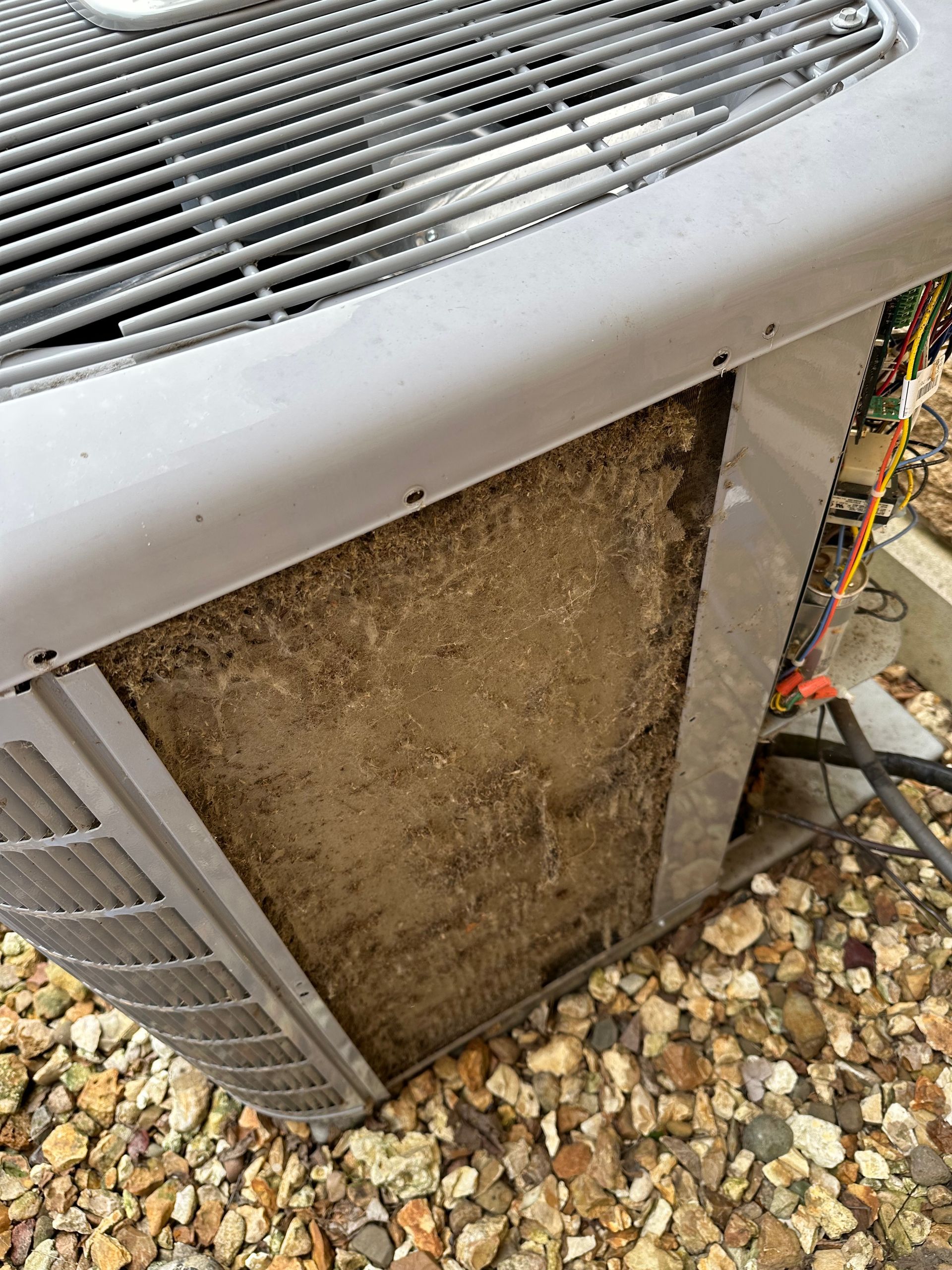 HVAC technician performing routine AC maintenance and cleaning to improve efficiency.