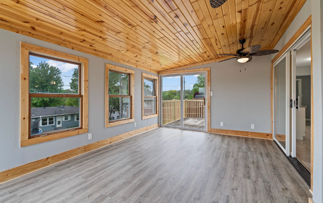 Cozy three-season room at Marmora with large windows, natural light, and a comfortable seating area.