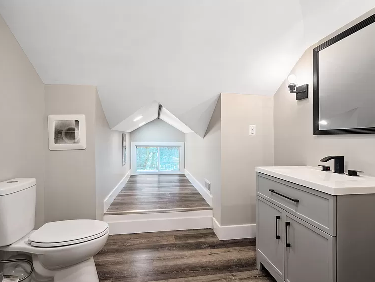 Charming attic bathroom at Fenelon featuring a vintage-inspired vanity, subway tile, and a compact yet stylish layout.