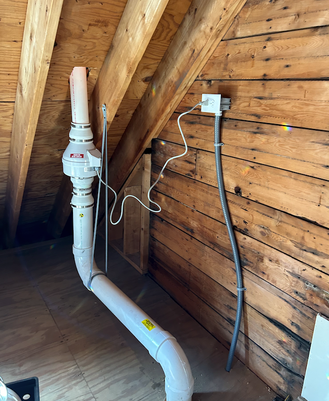A professional installing a radon mitigation system in a home's basement, ensuring safe indoor air quality for the residents.