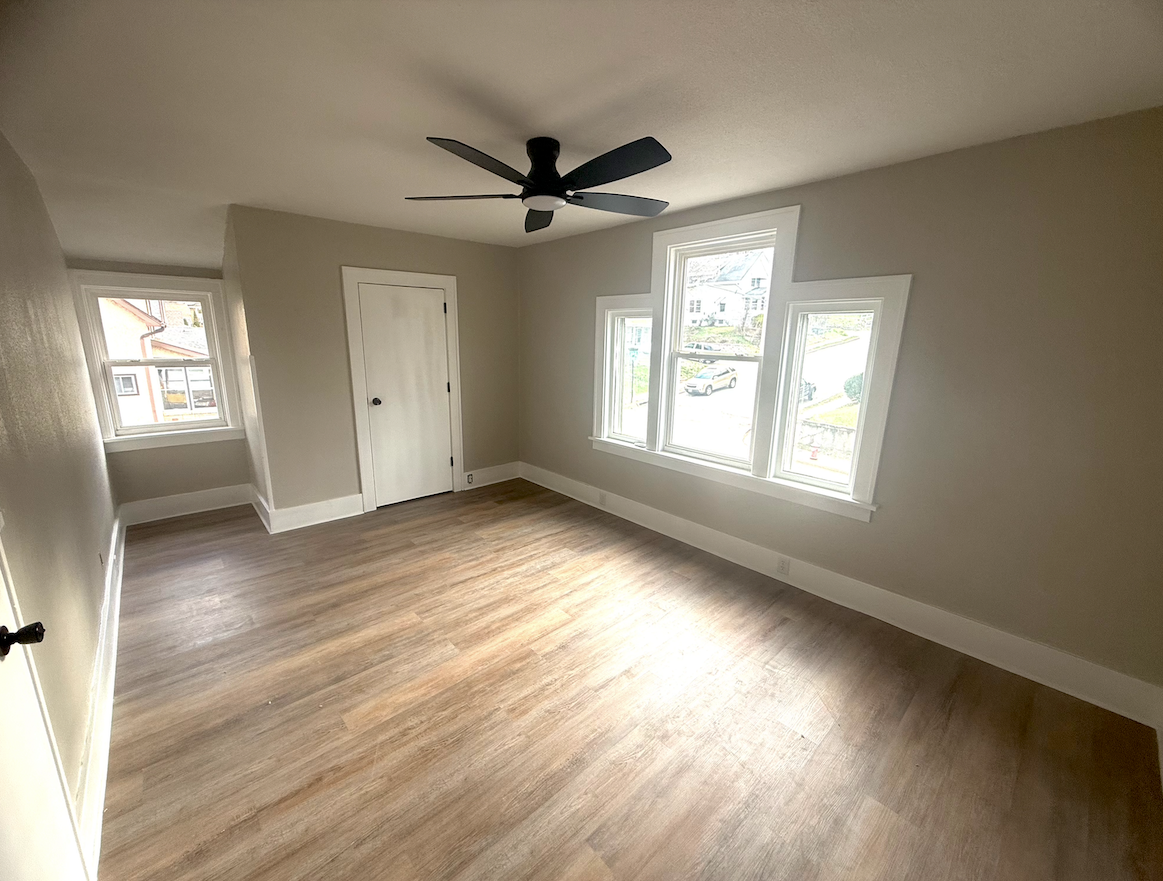 Spacious master bedroom with remodeled finishes and large windows