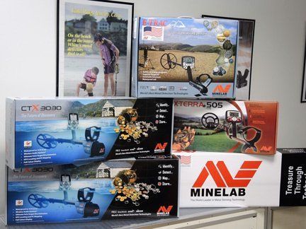 A bunch of boxes of minelab metal detectors are stacked on top of each other on a table.