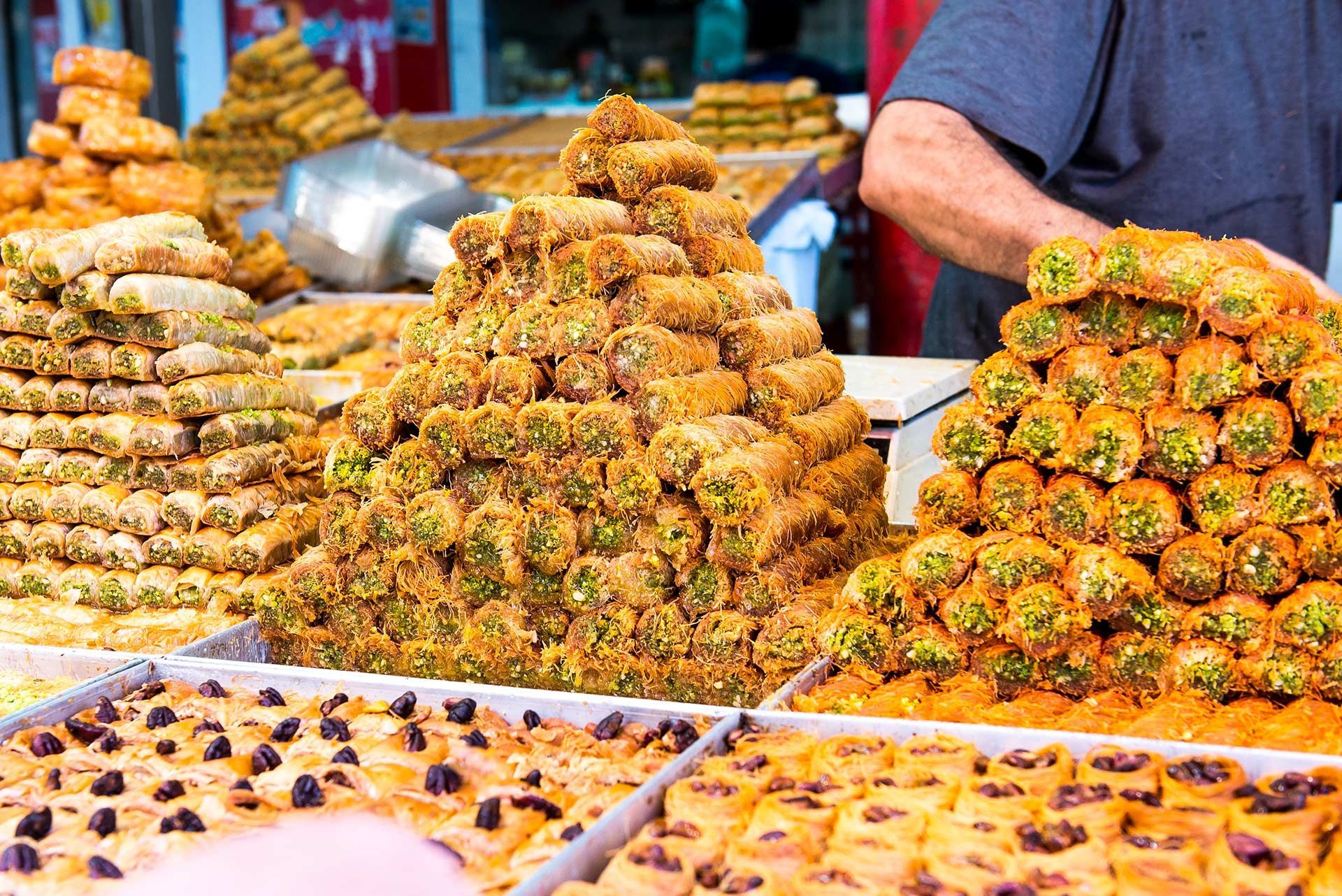 Street market display of colorful fried pastries and sweets on trays