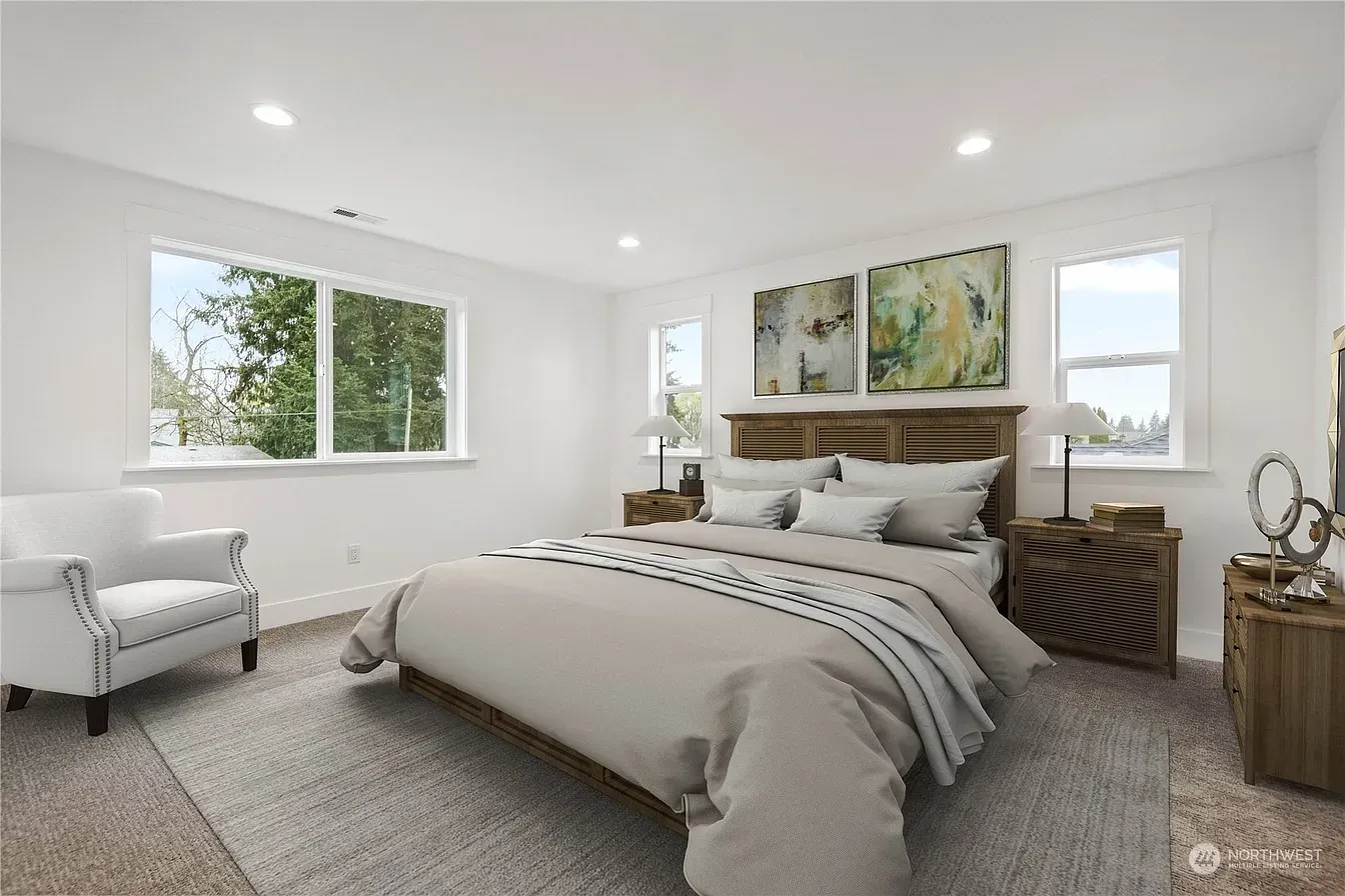 Bedroom with bed, armchair, nightstands, and artwork; neutral tones with natural light.