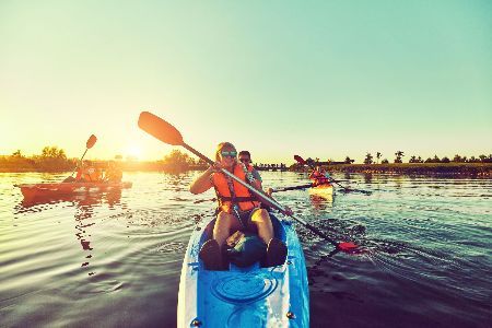 A group of people are paddling kayaks on a lake.