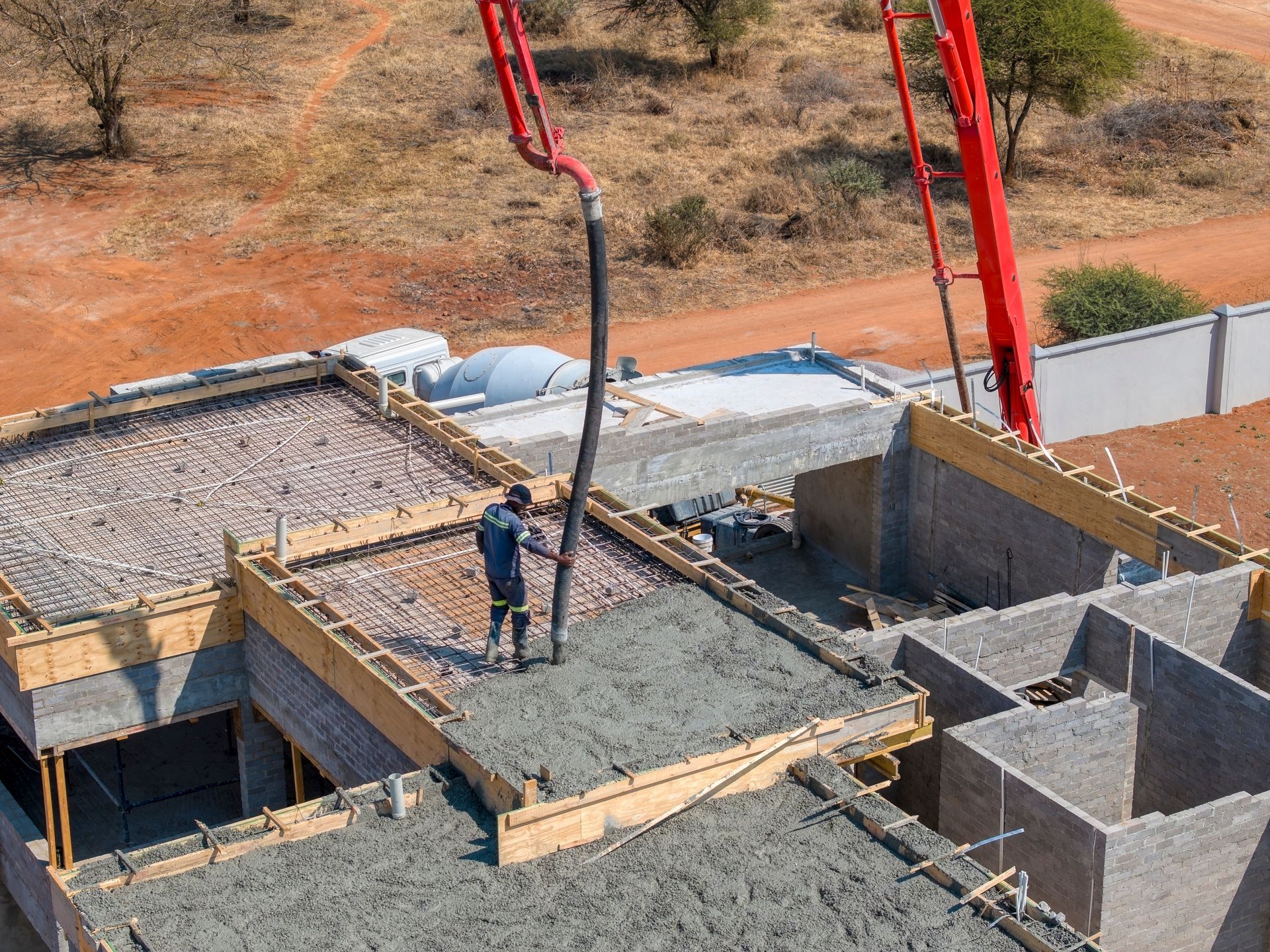 Construction Worker Pouring Concrete Onto a Roof With a Pump Truck — Salisbury Concrete Contractors In Byron Bay, NSW