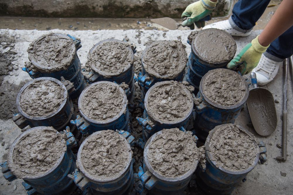 Concrete Cylinders Being Filled for Testing, Person Wearing Gloves — Salisbury Concrete Contractors In Tweed Heads, NSW
