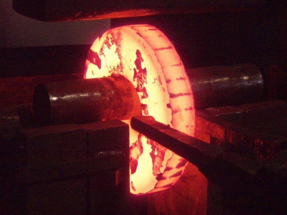Anello metallico incandescente su un albero di una macchina in un'officina buia