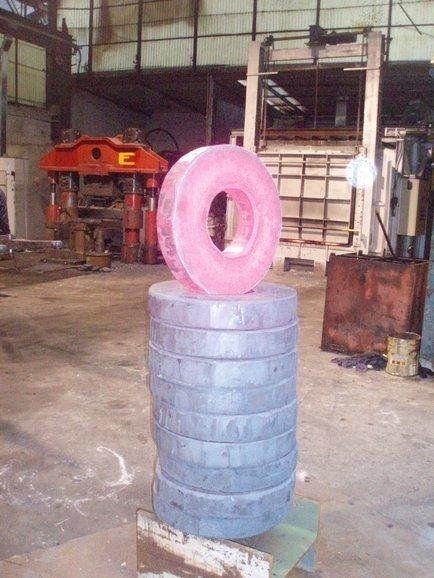 Pneumatico rosa su una pila di pneumatici blu in un magazzino industriale.