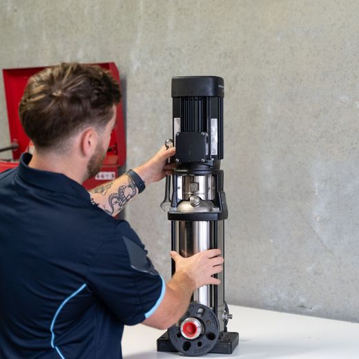 Technician installing a commercial pump system